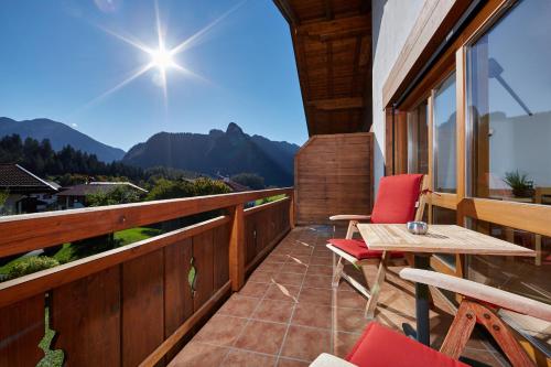 a balcony of a house with a table and chairs at Ferienhaus Alpinissimo in Oberammergau