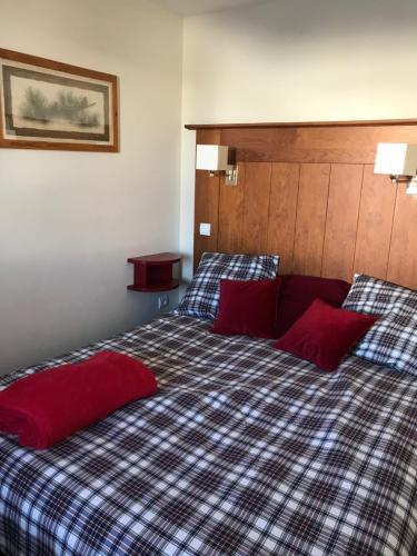 a bedroom with a bed with two red pillows at PLAGNE SOLEIL - 5 pers - 4 étoiles Paradiski - vue montagne - accès direct pistes et sentiers in La Plagne Tarentaise