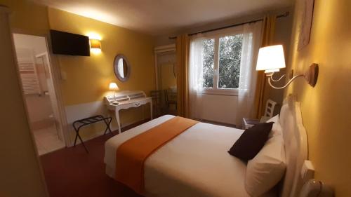 Un pat sau paturi într-o cameră la Hôtel du Tricastin