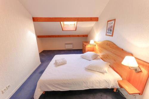 a bedroom with a large bed with white sheets and pillows at Résidence Plein Soleil in Avrieux