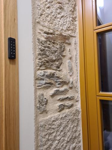 a stone wall with fossils on it next to a door at Casa da Marquesa Sarria in Sarria
