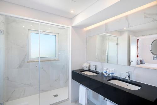 a bathroom with two sinks and a shower at Royal Obidos Scenic Resort in Casal da Lagoa Seca