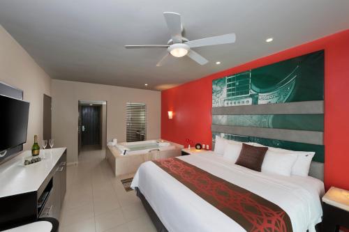 a bedroom with a large bed and a bathroom at Hard Rock Hotel Vallarta All Inclusive in Nuevo Vallarta