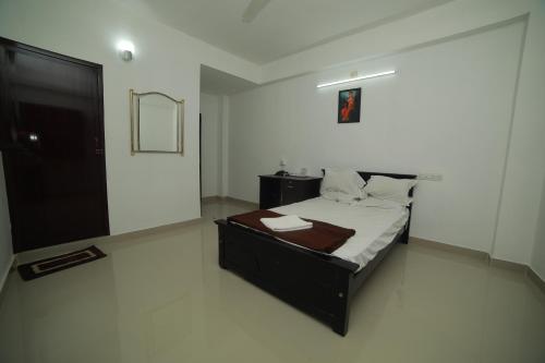 a bedroom with a bed and a mirror on the wall at MEGHNA RESIDENCY in Trivandrum