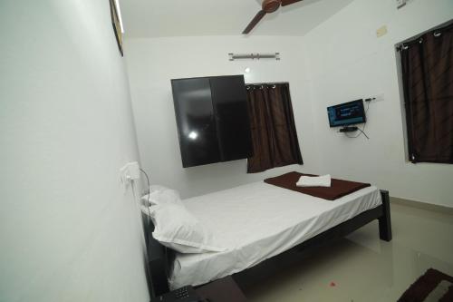 a hospital room with a bed and a tv at MEGHNA RESIDENCY in Trivandrum