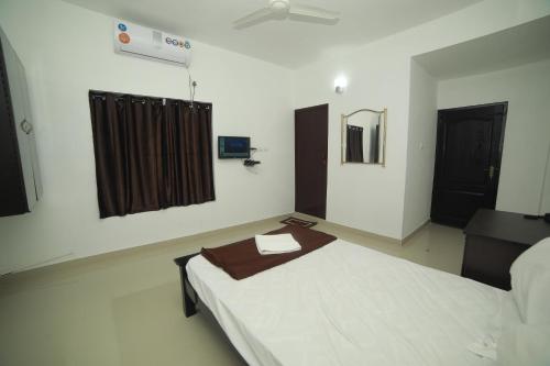 a room with a bed and a mirror in it at MEGHNA RESIDENCY in Trivandrum