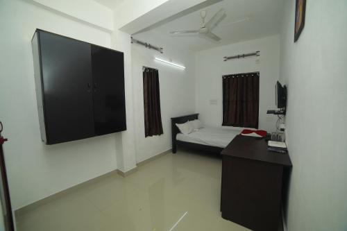 a living room with a large flat screen tv on the wall at MEGHNA RESIDENCY in Trivandrum