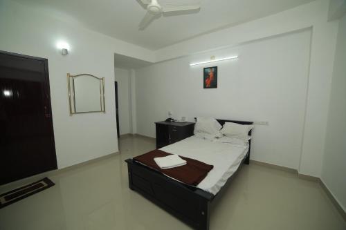 a bedroom with a bed in a room with a ceiling at MEGHNA RESIDENCY in Trivandrum