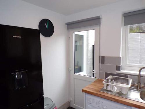 eine Küche mit einem schwarzen Kühlschrank und einem Fenster in der Unterkunft City Beach AirBnB Southend on Sea, in Southend-on-Sea
