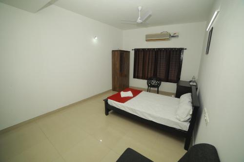 a bedroom with a bed with a red folder on it at MEGHNA RESIDENCY in Trivandrum