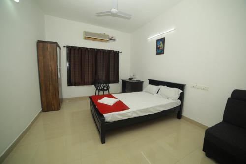 a bedroom with a bed with a red blanket at MEGHNA RESIDENCY in Trivandrum