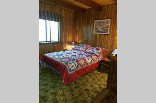 a bedroom with a bed in a wooden room at Regent Hilltop Cabin in Sandyville
