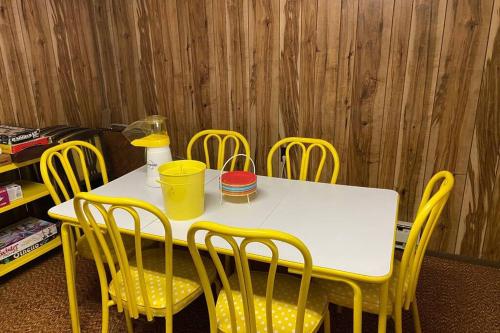 a table and chairs with a white table and yellow chairs at Regent Hilltop Cabin in Sandyville