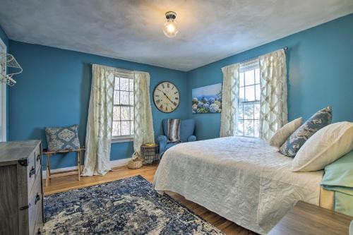 Dormitorio azul con cama y reloj en la pared en Hampton Quiet Corner Cottage with Fireplace and Yard, 