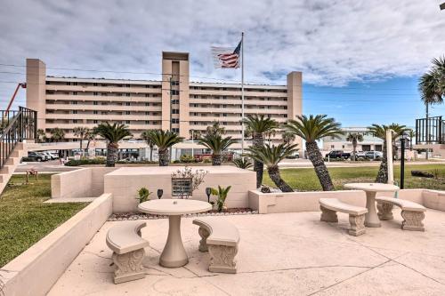 a group of tables and benches in front of a building at Ponce Inlet Condo with Beach and Pool Access! in Ponce Inlet