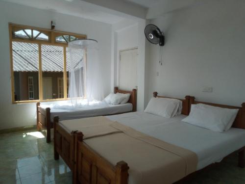 two beds in a room with a window at Green View Ella in Ella