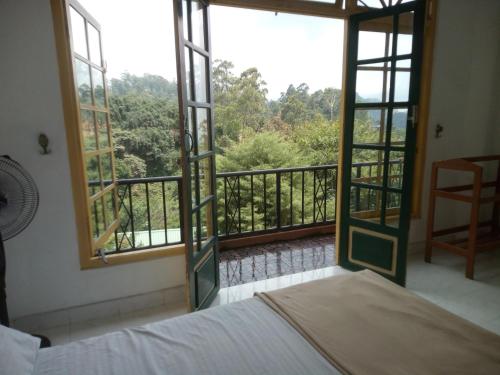 a bedroom with a bed and a view of a balcony at Green View Ella in Ella