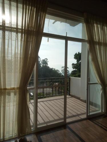 a view from the balcony of a house with a large window at Green View Ella in Ella