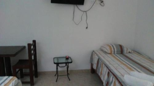 a bedroom with a bed and a table and a television at Olas inn in Asia