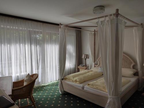 ein Schlafzimmer mit einem Himmelbett vor einem Fenster in der Unterkunft Condi Hotel in Hamburg