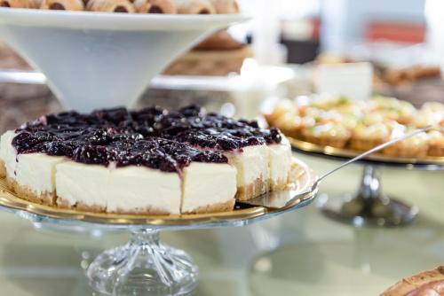 a blueberry cheesecake on a plate on a table at Barion Hotel & Congressi in Bari