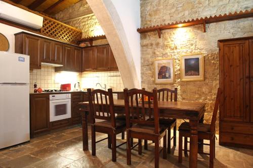 a kitchen with a wooden table with chairs and a refrigerator at Agrovino Lofou in Lofou