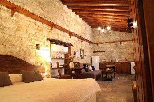 a bedroom with a bed and a kitchen in a room at Agrovino Lofou in Lofou