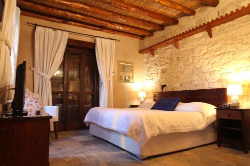 a bedroom with a bed and a tv in it at Agrovino Lofou in Lofou