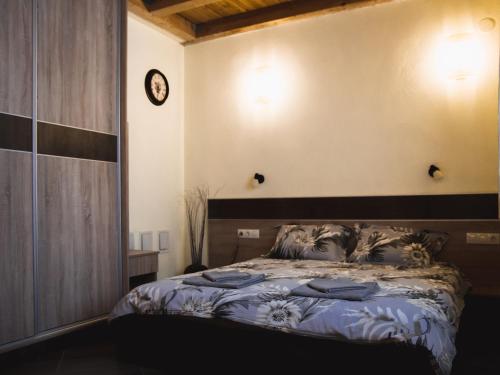 sypialnia z łóżkiem i zegarem na ścianie w obiekcie Relax w mieście Dobriniszte