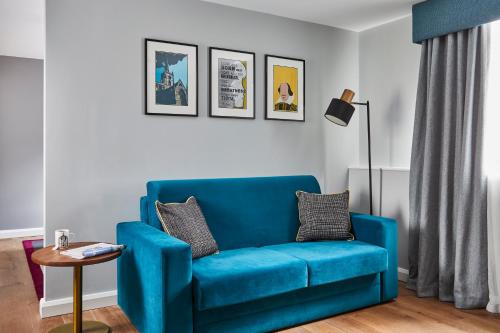 a blue couch sitting in a living room at Hotel Indigo - Stratford Upon Avon by IHG in Stratford-upon-Avon