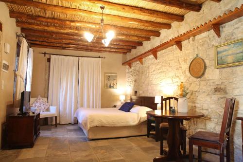 a bedroom with a bed and a table in a room at Agrovino Lofou in Lofou