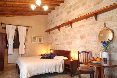 a bedroom with a bed and a table with a mirror at Agrovino Lofou in Lofou