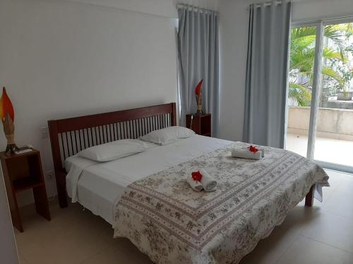 Un dormitorio con una cama con dos toallas encima. en Apartamentos no Pipa Residence, en Pipa