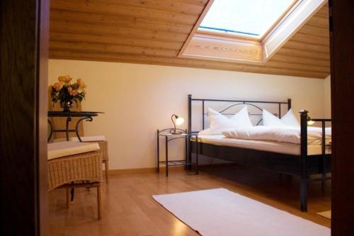 een slaapkamer met een bed en een dakraam bij Haus Steinbrecher in Anger