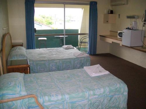 A bed or beds in a room at Sun Plaza Motel - Mackay