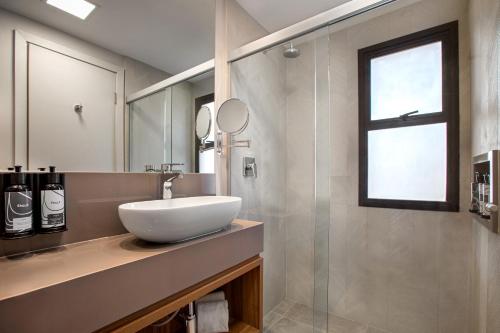 a bathroom with a sink, mirror, and bathtub at INNSIDE by Meliá São Paulo ITAIM in São Paulo