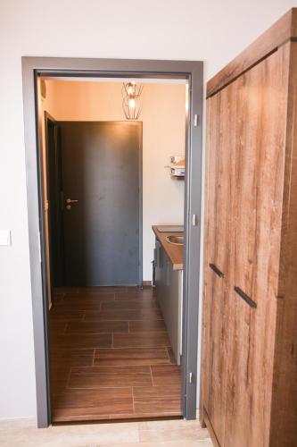 a door leading into a kitchen with a hallway with a counter at Balkon Apartmanház Panzió in Balatonfüred