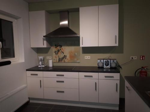 a kitchen with white cabinets and a stove at Vertentenhuis in Hamme