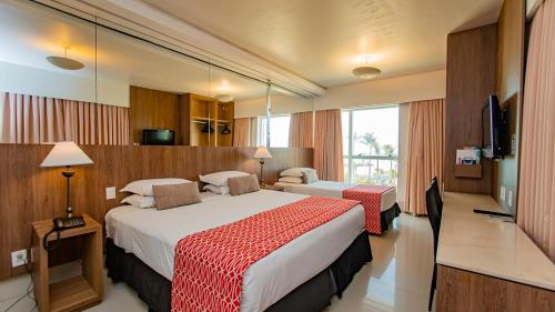 a hotel room with two beds and a television at Hotel Beira Mar in Fortaleza