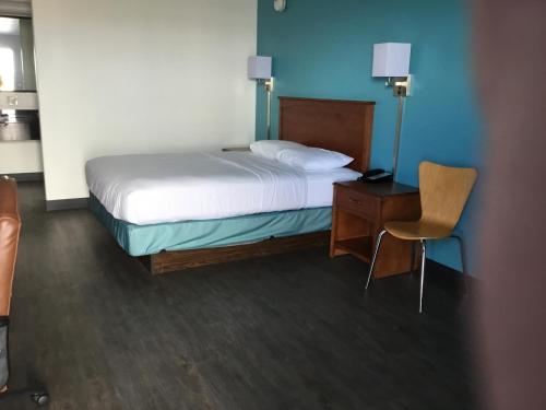 a bedroom with a bed and a desk and a chair at Motel 6-Baker City, OR in Baker City