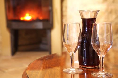 two wine glasses sitting on a table with a bottle of wine at Agrovino Lofou in Lofou