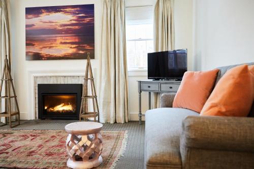 a living room with a couch and a fireplace at Shelter Harbor Inn in Westerly