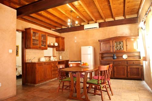 a kitchen with a table and chairs and a refrigerator at Agrovino Lofou in Lofou