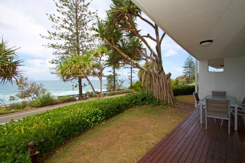 a porch with a table and chairs and the ocean at The Beach Retreat Coolum in Coolum Beach