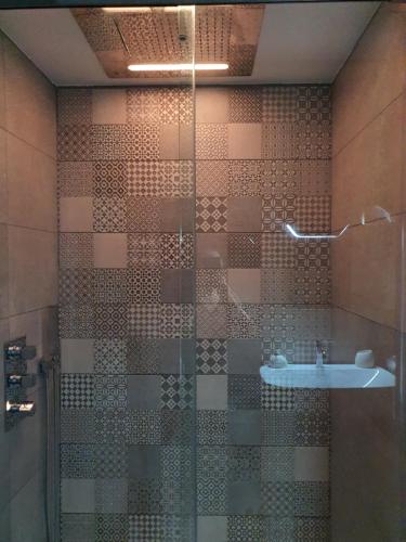 une salle de bain avec une douche en verre avec un lavabo dans l'établissement Appartement parc Marianne espace fitness, à Montpellier