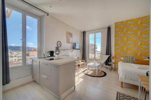 uma cozinha e sala de estar com uma grande janela em IMMOGROOM - Bourgeois building - Quiet - Parking - Sea view em Cannes