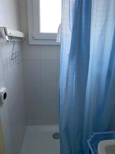 a bathroom with a shower with a blue shower curtain at Dorner Rustic Chalet in Gsteigwiler