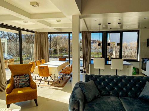 una sala de estar con un sofá, una mesa y sillas en Villa Una Residence, en Bihać