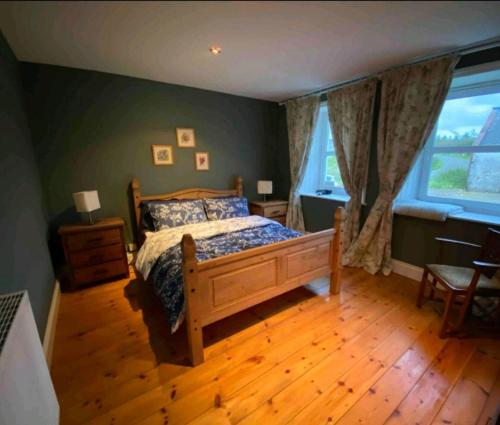 a bedroom with a bed and a wooden floor at Barcloy Honey House in Kirkcudbright