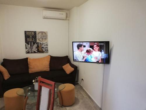 a living room with a couch and a tv on a wall at Apartment Rota in Zadar